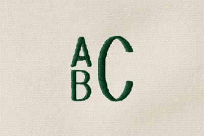 The letters "ABC" monogrammed in green thread on cream-colored canvas, A and B stacked to the left and the C on the right